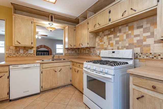 kitchen featuring white appliances, a ceiling fan, light countertops, a sink, and backsplash