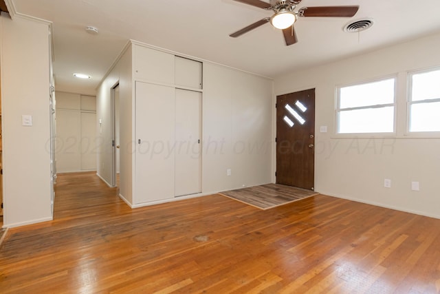 entryway with light wood finished floors, a ceiling fan, and visible vents