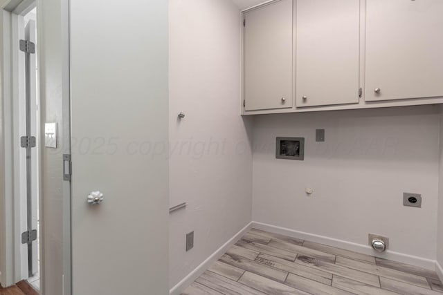 washroom with baseboards, washer hookup, light wood-type flooring, hookup for an electric dryer, and cabinet space