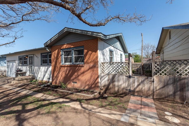 view of side of property with crawl space and fence