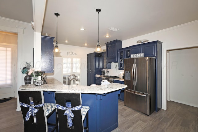 kitchen featuring a kitchen breakfast bar, blue cabinetry, stainless steel appliances, a peninsula, and wood finished floors