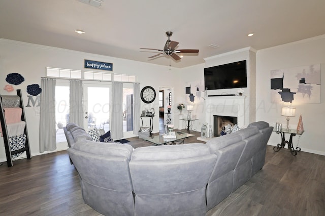 living area featuring a premium fireplace, a ceiling fan, crown molding, and dark wood-style floors