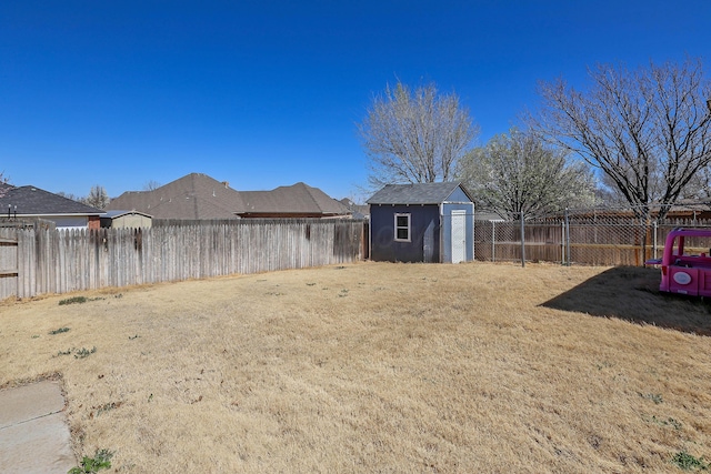 view of yard featuring a fenced backyard, an outdoor structure, and a storage shed
