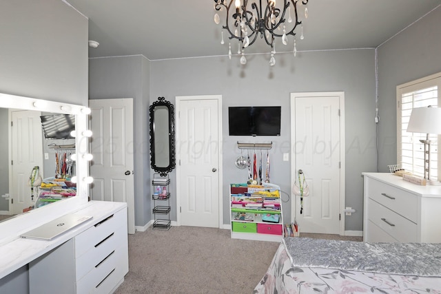 carpeted bedroom with baseboards and a chandelier
