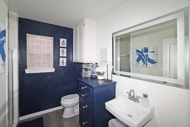 full bathroom with an enclosed shower, toilet, a sink, and wood finished floors