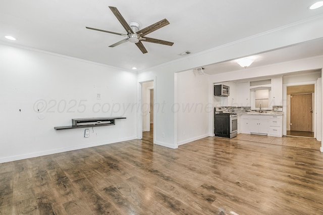 unfurnished living room featuring visible vents, a sink, a ceiling fan, crown molding, and recessed lighting