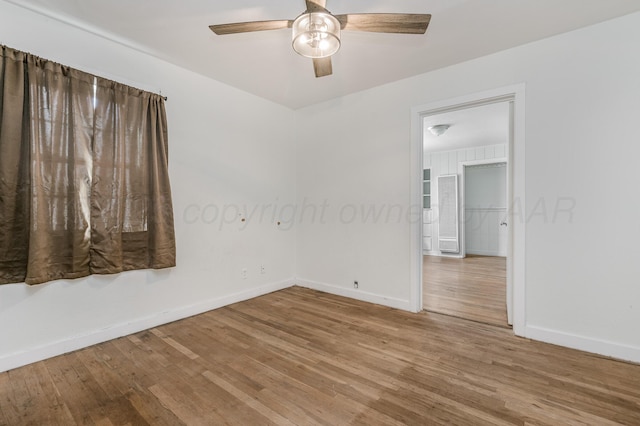 empty room with baseboards, a ceiling fan, and wood finished floors