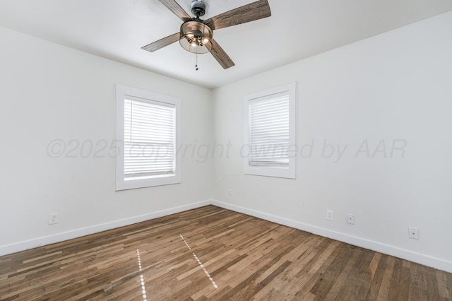 unfurnished room with baseboards, wood finished floors, and a healthy amount of sunlight