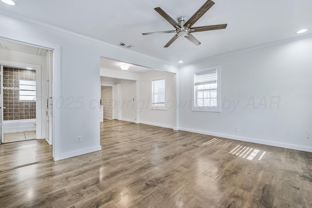 unfurnished room featuring crown molding, baseboards, a ceiling fan, and visible vents