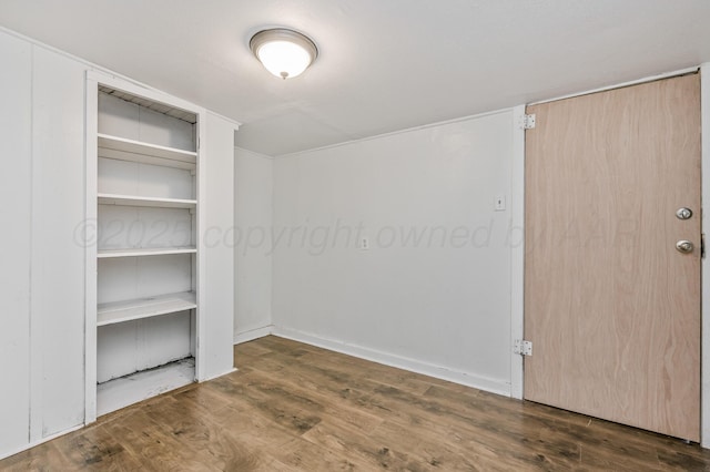 unfurnished bedroom featuring baseboards and wood finished floors
