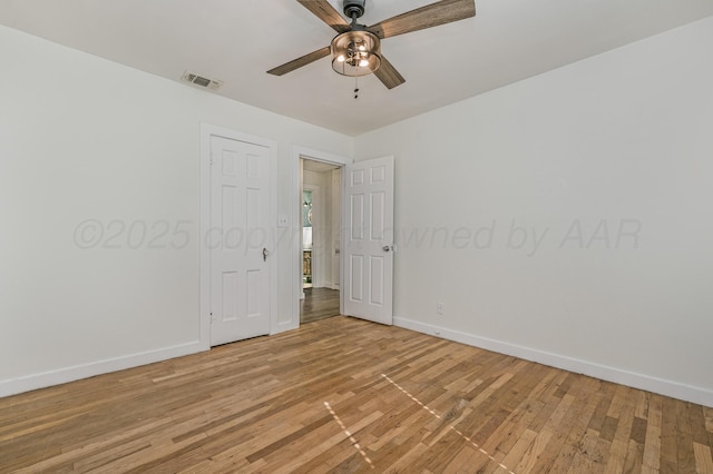 empty room with visible vents, baseboards, a ceiling fan, and light wood-style flooring