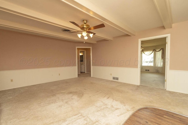 4903 Princeton St, Amarillo, TX 79109 - empty room featuring beam ceiling, a wainscoted wall, carpet flooring, and a ceiling fan