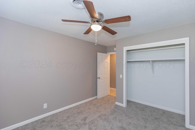 unfurnished bedroom with ceiling fan, a closet, light colored carpet, and a textured ceiling