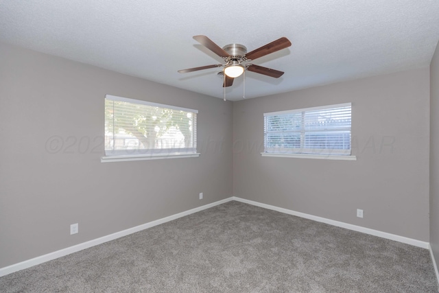 carpeted empty room featuring ceiling fan and a textured ceiling