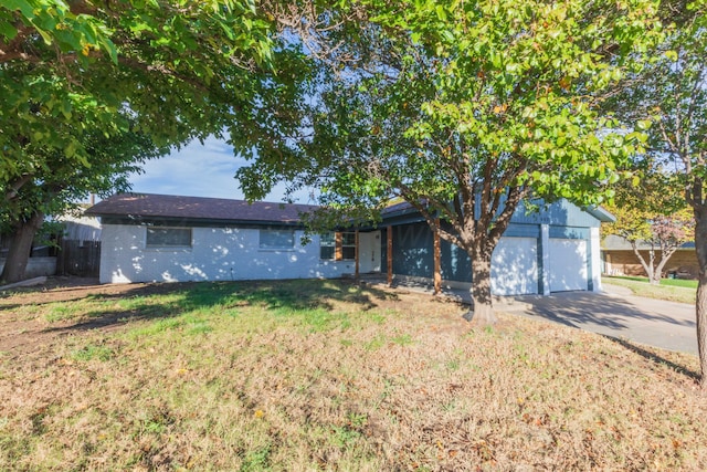 single story home with a garage and a front lawn