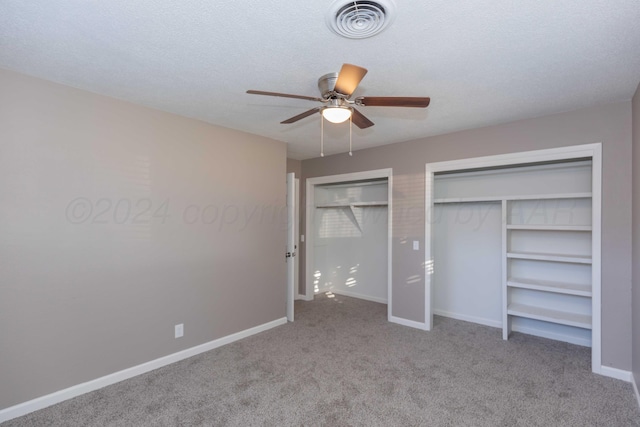 unfurnished bedroom featuring ceiling fan, light carpet, and a textured ceiling