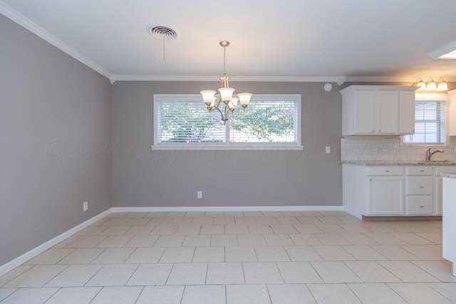 kitchen with backsplash, crown molding, light tile patterned floors, white cabinetry, and hanging light fixtures