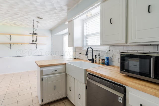 5210 S Milam St, Amarillo, TX 79110 - kitchen with wooden counters, stainless steel appliances, decorative backsplash, light tile patterned flooring, and decorative light fixtures