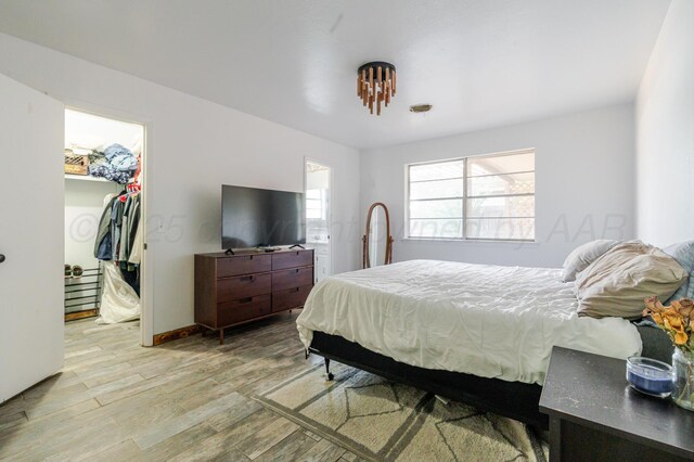 5210 S Milam St, Amarillo, TX 79110 - bedroom with a spacious closet, light wood finished floors, a closet, and ensuite bath