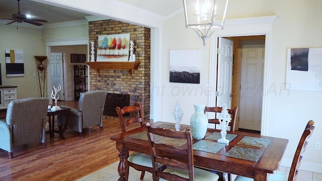 dining area with light tile patterned flooring, crown molding, and ceiling fan with notable chandelier