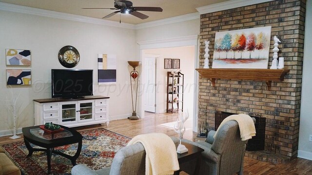 living room featuring wood finished floors, crown molding, baseboards, a fireplace, and ceiling fan
