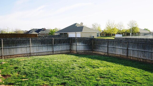 view of yard featuring a residential view and a fenced backyard