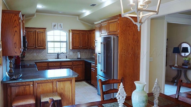 kitchen featuring high end refrigerator, decorative backsplash, a peninsula, black dishwasher, and visible vents