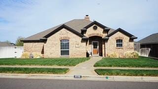 french provincial home featuring a front lawn, stone siding, and a chimney