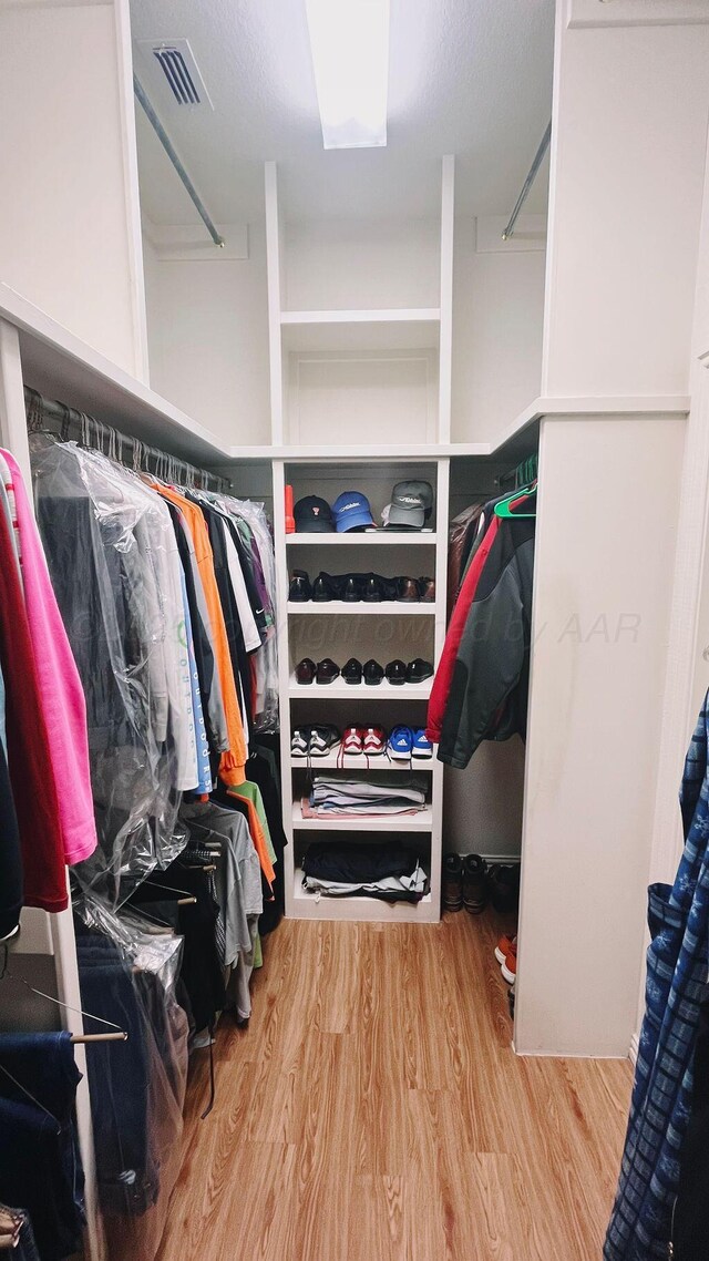 walk in closet featuring wood finished floors and visible vents
