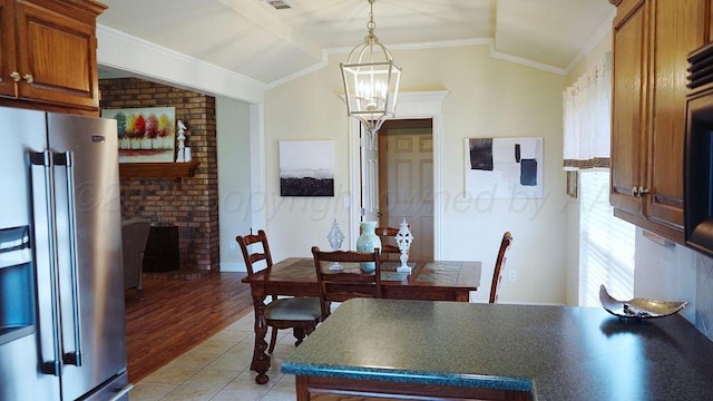 dining area with crown molding, a chandelier, light wood-style floors, lofted ceiling, and visible vents