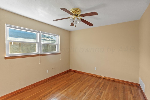 unfurnished room with visible vents, baseboards, and wood finished floors