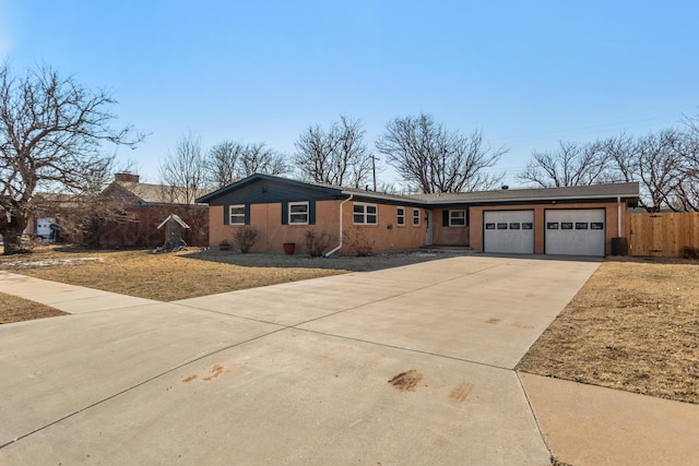 ranch-style house featuring driveway, a garage, fence, and a front lawn