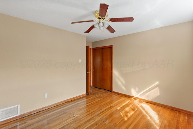 unfurnished room featuring ceiling fan, light wood finished floors, visible vents, and baseboards