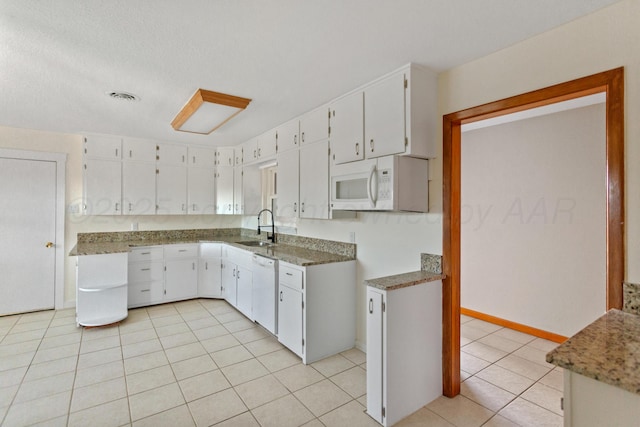 kitchen featuring light tile patterned floors, white appliances, a sink, visible vents, and white cabinets