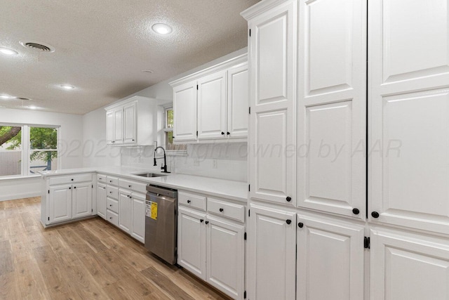 2607 15th Ave, Canyon, TX 79015 - kitchen featuring dishwasher, a sink, a textured ceiling, white cabinetry, and light countertops