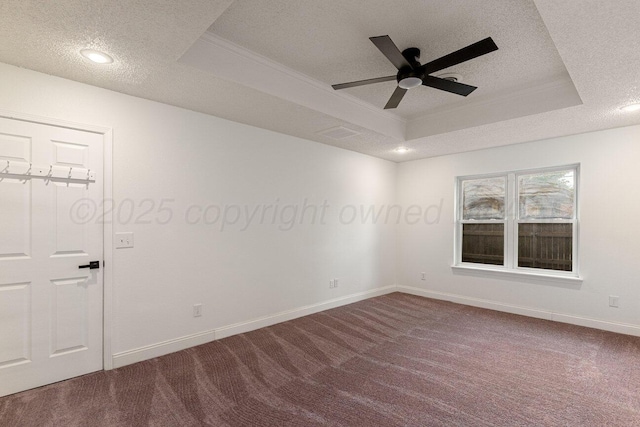 2607 15th Ave, Canyon, TX 79015 - empty room featuring a tray ceiling, a textured ceiling, dark carpet, baseboards, and a ceiling fan