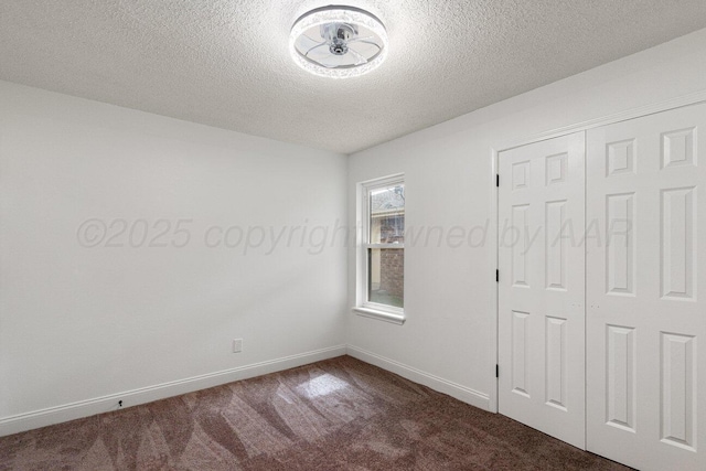 2607 15th Ave, Canyon, TX 79015 - unfurnished bedroom with dark colored carpet, a textured ceiling, baseboards, and a closet