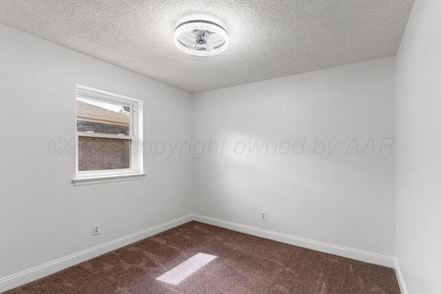 2607 15th Ave, Canyon, TX 79015 - unfurnished room featuring dark carpet, a textured ceiling, and baseboards