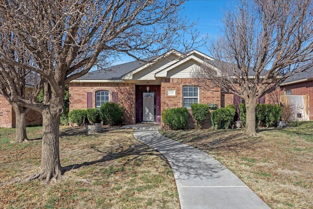 ranch-style house with brick siding and a front yard