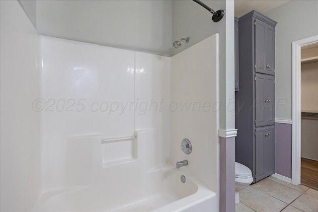 bathroom with shower / bathing tub combination, toilet, and tile patterned flooring