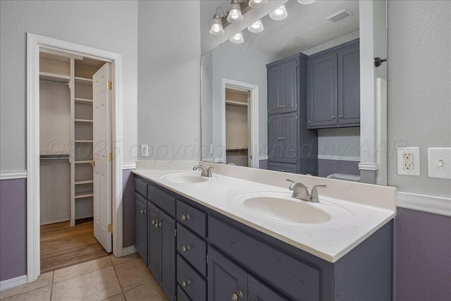 full bath with tile patterned flooring, double vanity, visible vents, and a sink