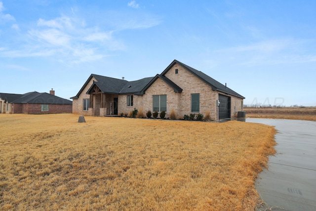 view of front of house featuring a garage and a front lawn