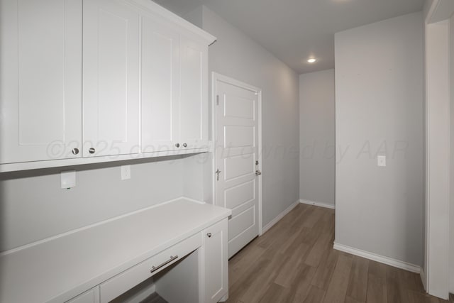 hallway with hardwood / wood-style floors