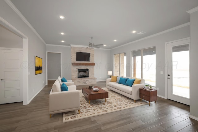 living room with dark hardwood / wood-style floors, ceiling fan, a fireplace, and crown molding