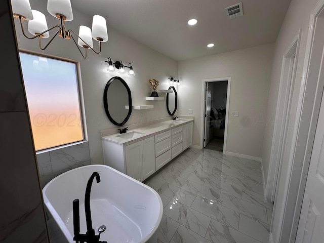 1513 SE 11th Ave, Amarillo, TX 79102 - ensuite bathroom featuring marble look tile flooring, double vanity, recessed lighting, a freestanding bath, and a chandelier