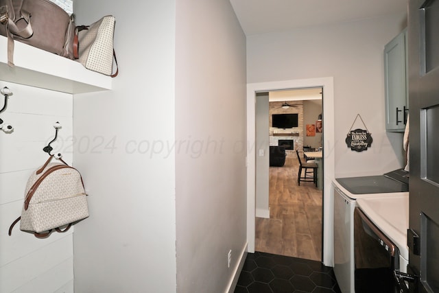 laundry area with a fireplace, separate washer and dryer, cabinets, and dark wood-type flooring