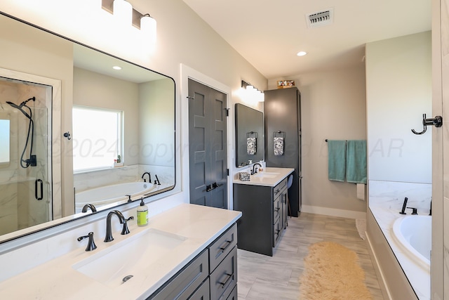 bathroom with vanity and shower with separate bathtub