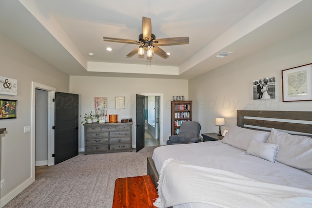 bedroom with a tray ceiling, ceiling fan, and carpet