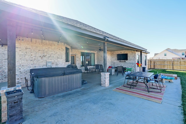 view of patio / terrace with ceiling fan and a hot tub