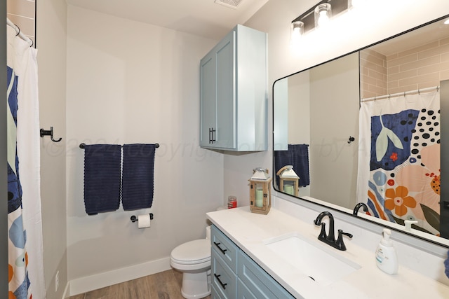 bathroom with hardwood / wood-style flooring, vanity, curtained shower, and toilet